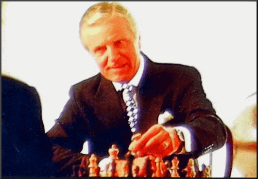 Gentleman playing chess wearing a Excalibur Nicole Miller designer tie.
